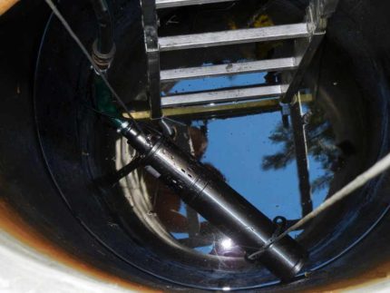 Installation of a submersible water pump in a well Lowering the submersible pump
