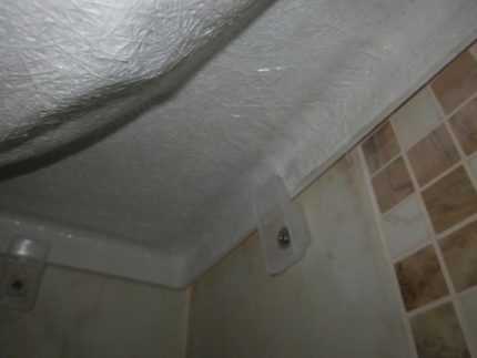 Bevestiging van het acrylbad aan de muur bij installatie op de poten Het bad aan de muur bevestigen