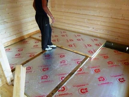 Pose d'une feuille isolante pour un plancher chauffant Dépliage des plaques de support