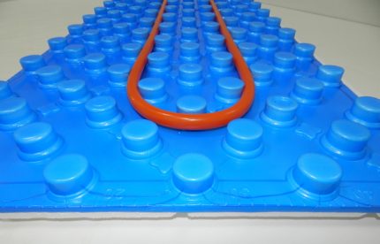 Tapis avec bossages pour faciliter la pose d'un plancher d'eau chaude Tapis de profil avec boss