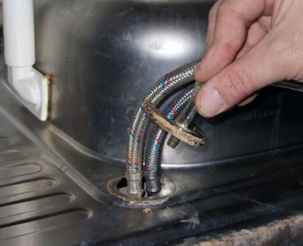Voorbereiden om de oude kraan in de keuken te vervangen en een nieuwe te installeren Moeren losmaken