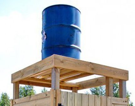 Vat tank voor een zomerse douche op een houten steun Vat van een zomer douche op een houten steun
