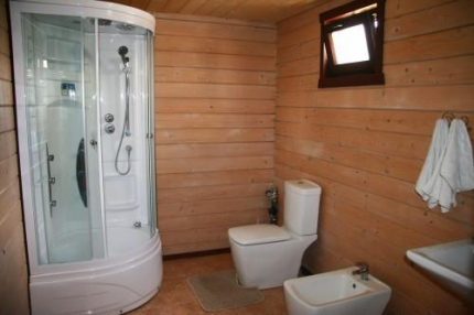 Salle de bain dans le système d'égouts local dans le pays Salle de bain dans une maison de campagne en bois