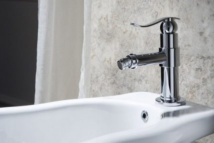 Bidetmixer gemonteerd op een bidet Bevestiging van de mixer op het bidet