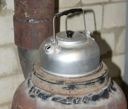 Kettle sa isang self-made gas stove mula sa isang silindro ng gas Ang ibabaw ng pagluluto ng isang potbelly stove