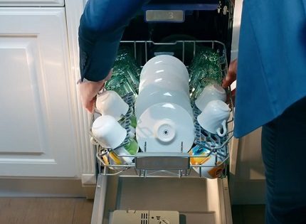 Разтоварване на измитите съдове Съдове в съдомиялна кошница