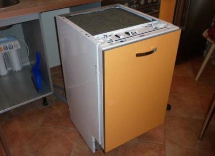 Le processus d'installation de la façade sur le PMM Le lave-vaisselle est sorti de l'armoire