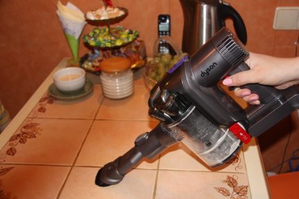 Cleaning the crumbs from the table with a vacuum cleaner Cleaning the table with a vacuum cleaner