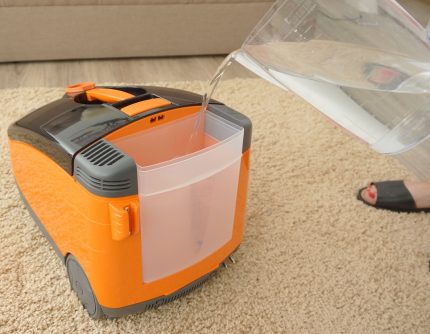 Filling the water tank of the co-vacuum cleaner with water Pouring water into the vacuum cleaner compartment