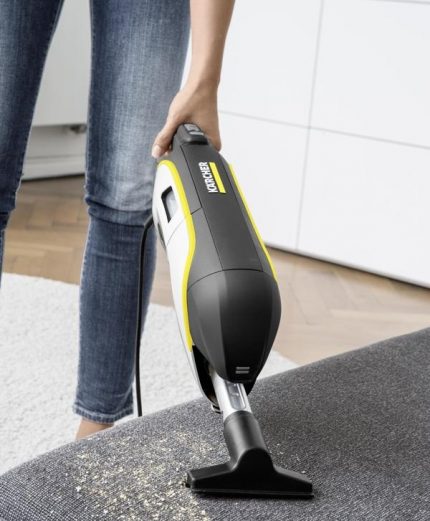 Using the portable part of a vertical vacuum cleaner to clean the sofa Upholstery cleaning