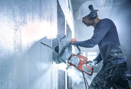 The process of cutting a niche for mounting an electrical panel Circular saw for carving a niche in the wall
