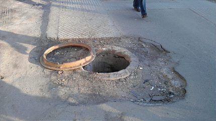 Cast iron hatches are often stolen and handed over for scrap Open sewer well on the road