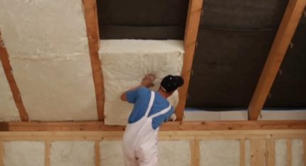 Laying heat-insulating mats between rafters Laying minvata between rafters