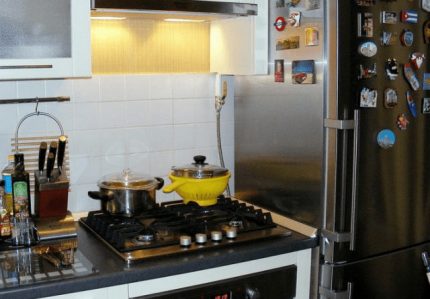Une cuisinière près du réfrigérateur Une cuisinière près du réfrigérateur